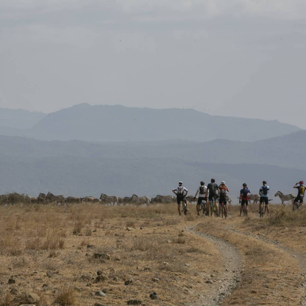 Deelnemer Africa Classic steekt zijn duim op tijdens het fietsen op een dirt road