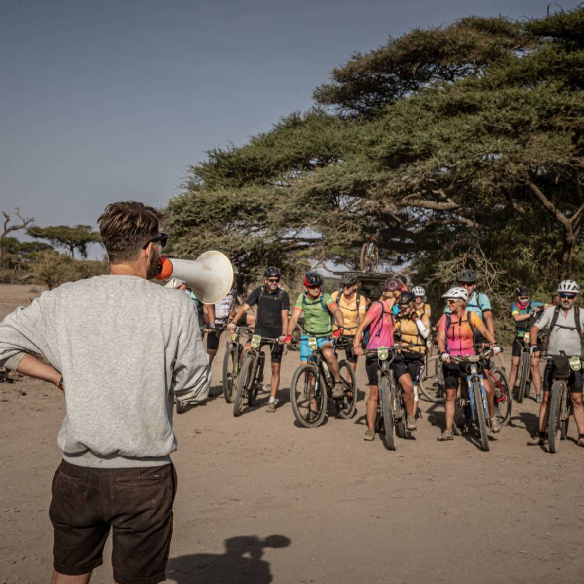 Organisator van Africa Classic spreekt de deelnemers toe voordat ze op de fiets stappen