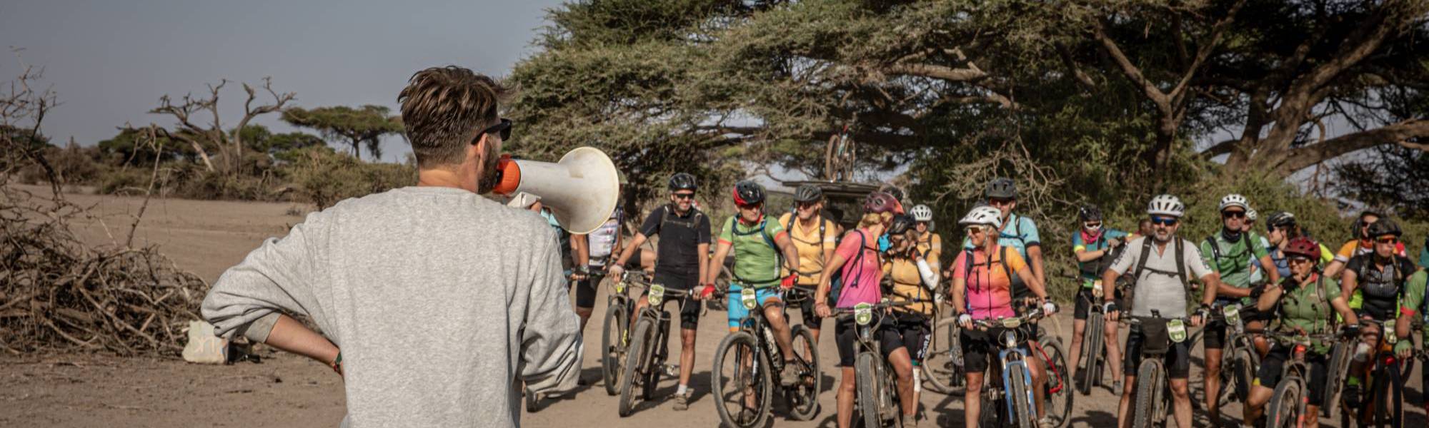 Organisator van Africa Classic spreekt de deelnemers toe voordat ze op de fiets stappen