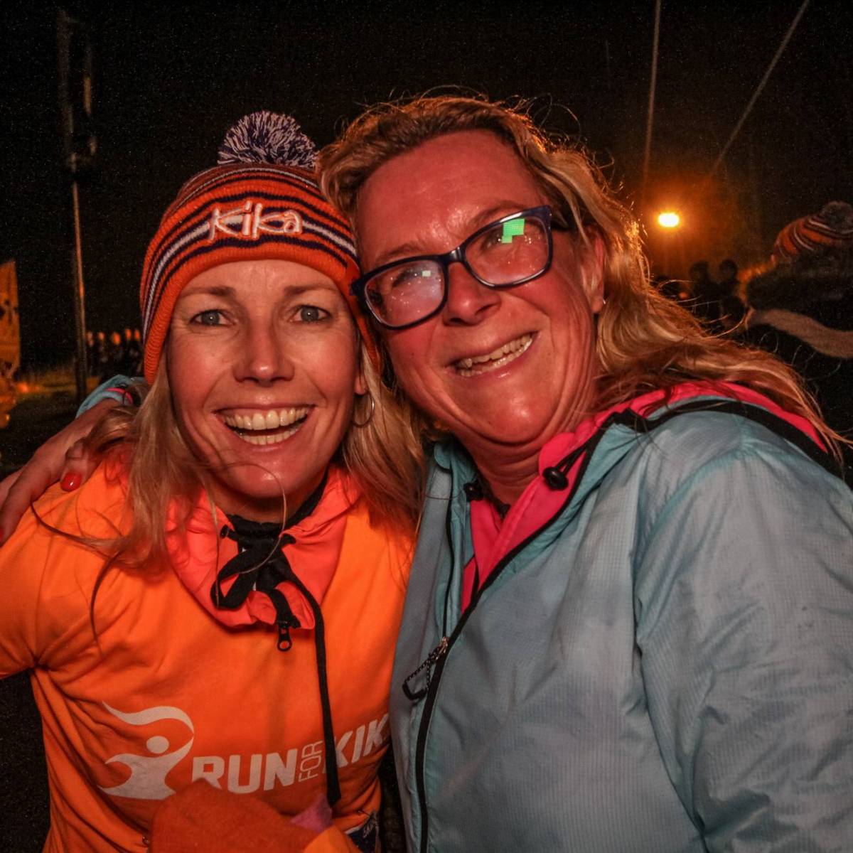 Meerdere mensen met een Run for KiKa shirt aan, handen bij elkaar.