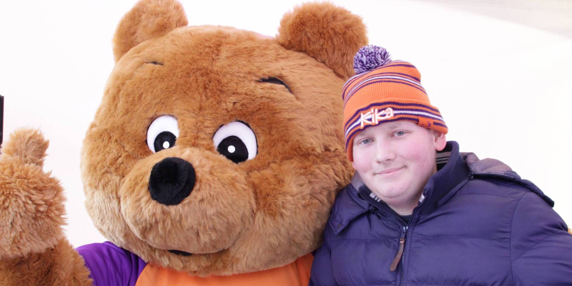 Meerdere mensen met een Run for KiKa shirt aan, handen bij elkaar.