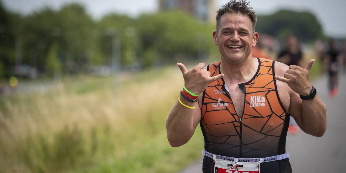 Deelnemer die zijn medaille ontvangt van de IRONMAN organisatie in het finishgebied