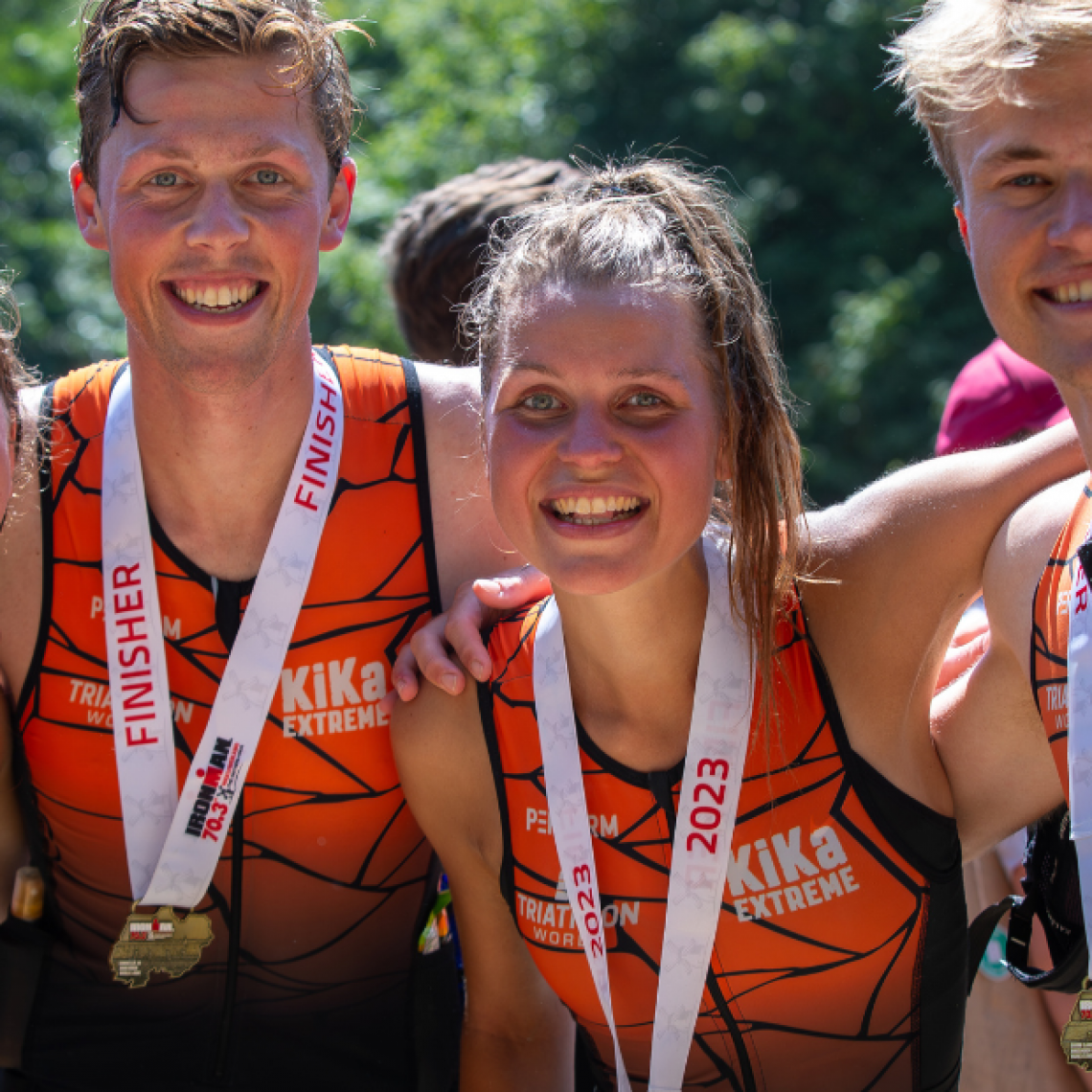 Deelnemer die zijn medaille ontvangt van de IRONMAN organisatie in het finishgebied