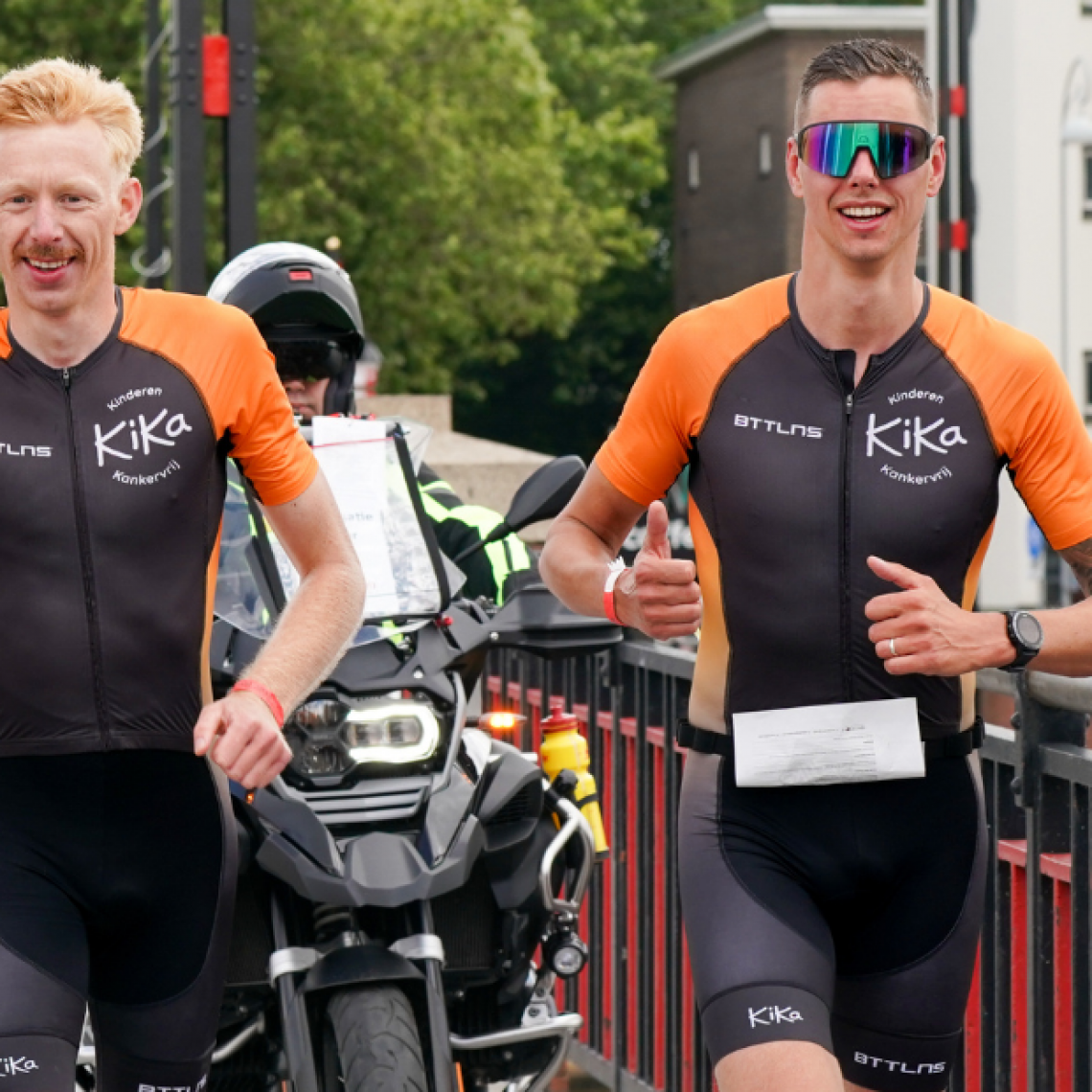 Deelnemer die fietst voorbij een typisch Nederlandse molen in Westfriesland