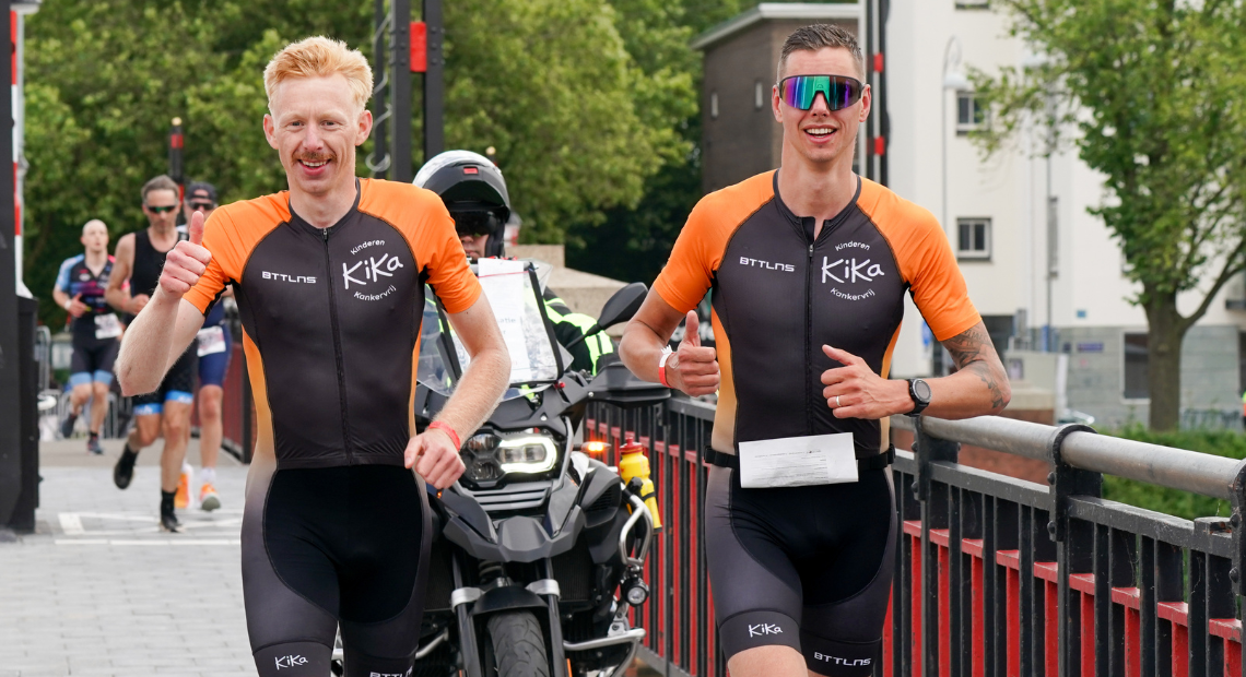 Deelnemer die fietst voorbij een typisch Nederlandse molen in Westfriesland